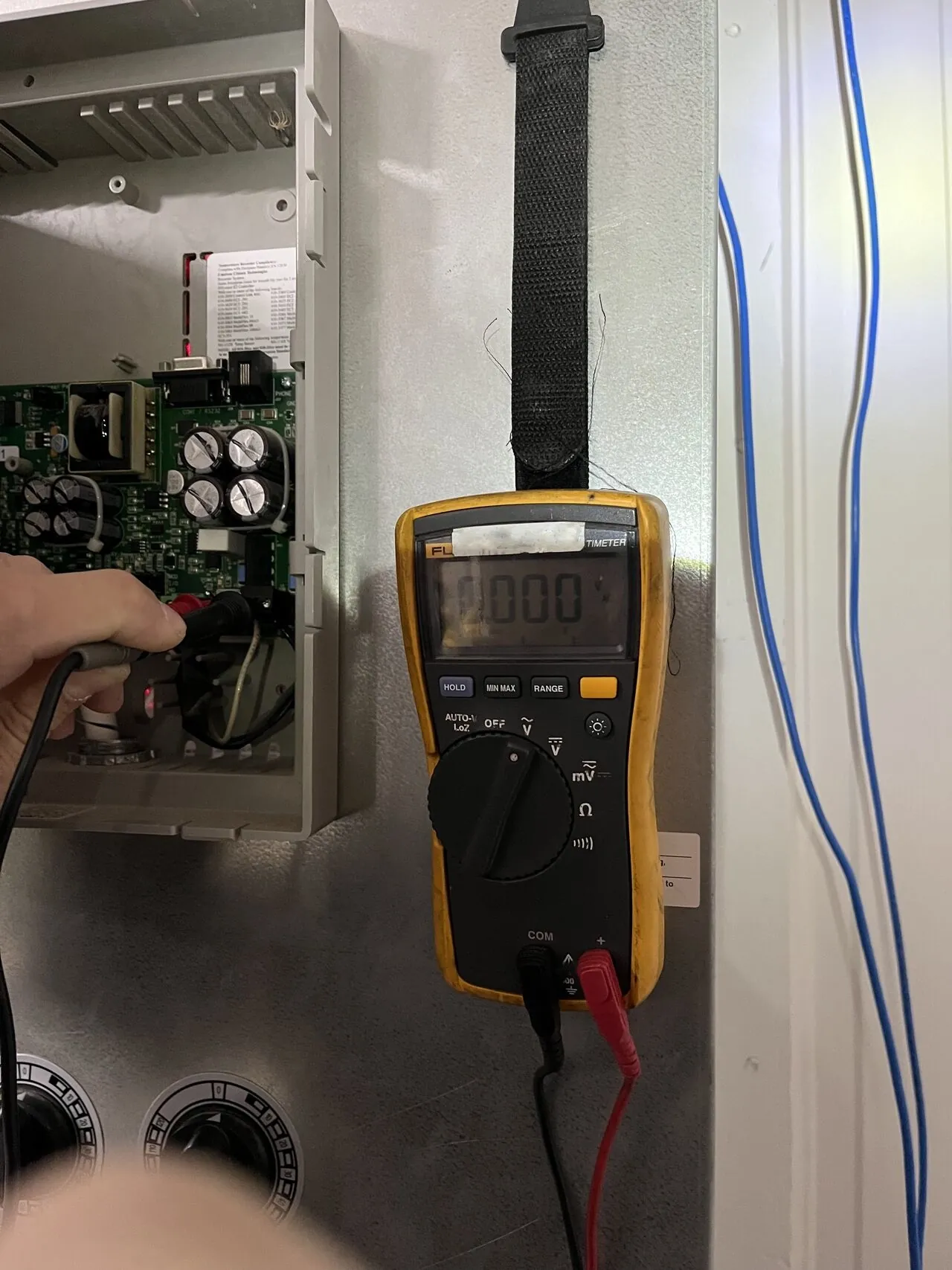 Technician testing a UPS system with a multimeter at an Arizona facility